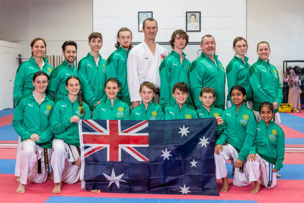 The 2023 Sunshine Coast Karate team in Australian green, with Martin, holding the Australian flag