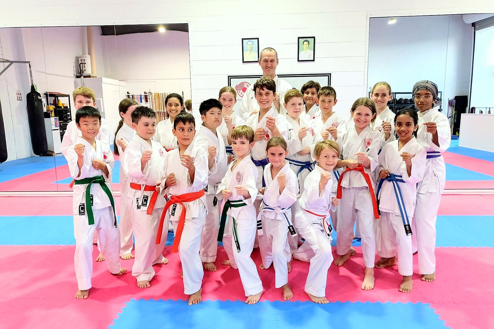A big group of students in fighting stance with Sensei Martin