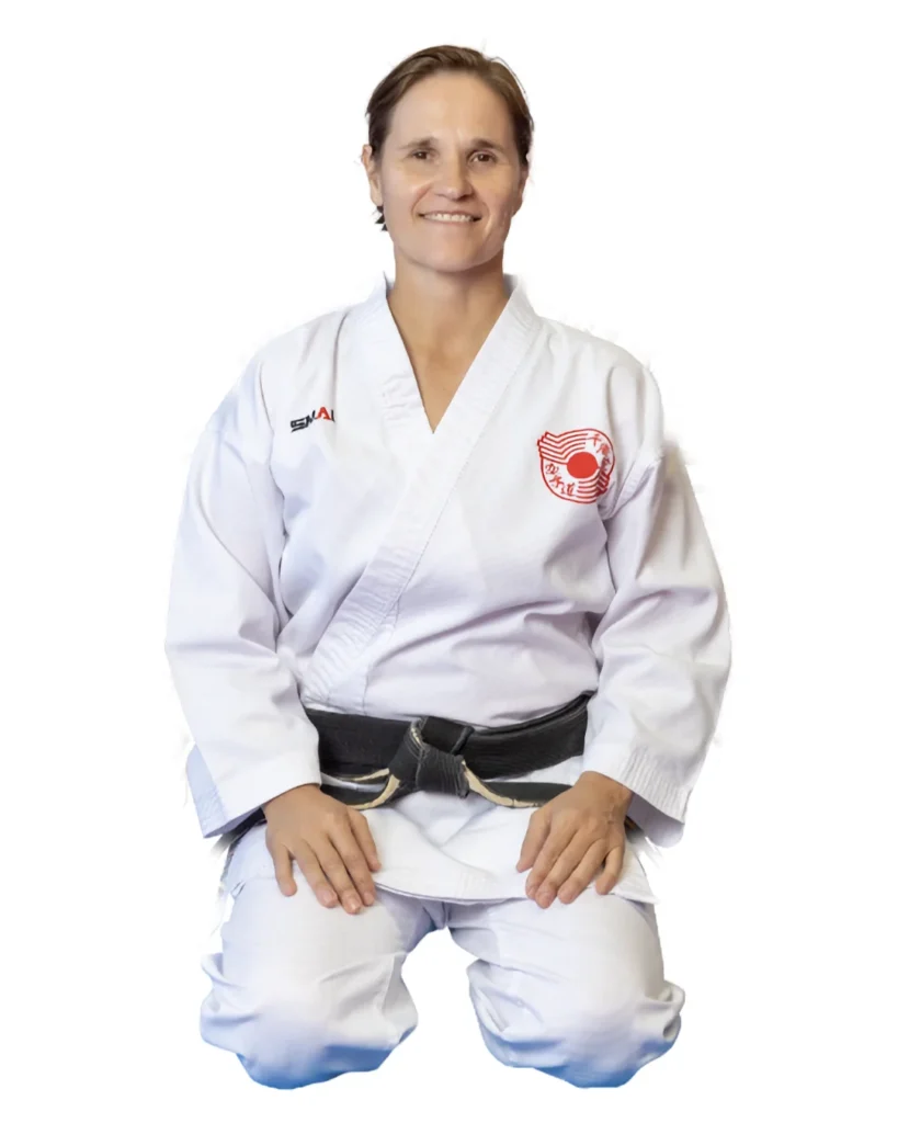 Sandra Phillips Sensei, kneeling, in her gi and black belt
